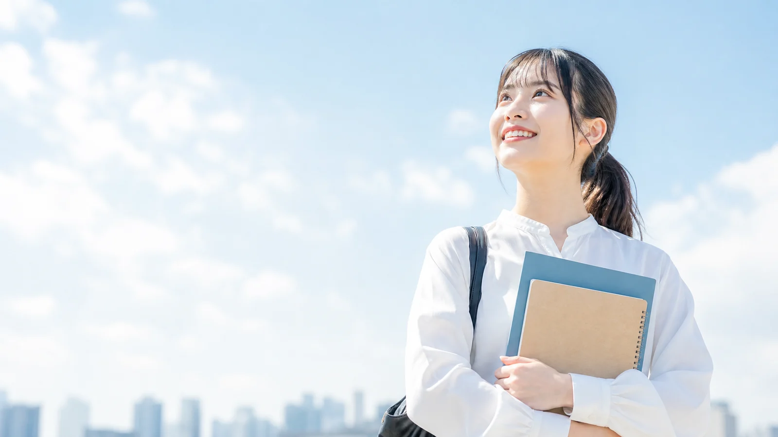 青空を見上げる大学生